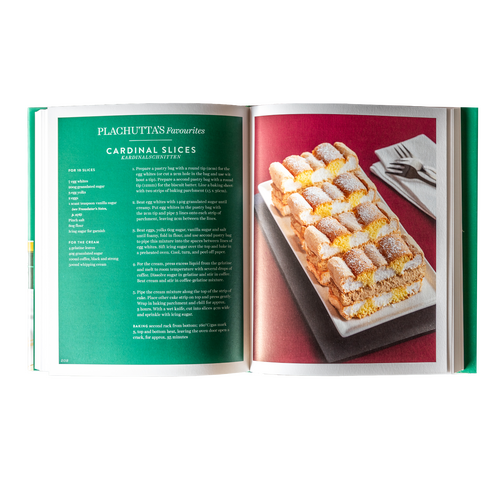 On a sunny day, the wooden balcony with glass railings offers a view of a grassy backyard and the houses in the neighborhood.