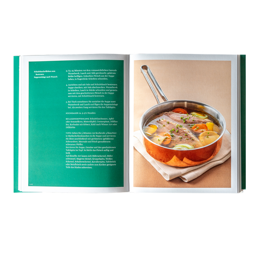 Open cookbook with a recipe on the left and a pot of meat and vegetables in broth on the right.